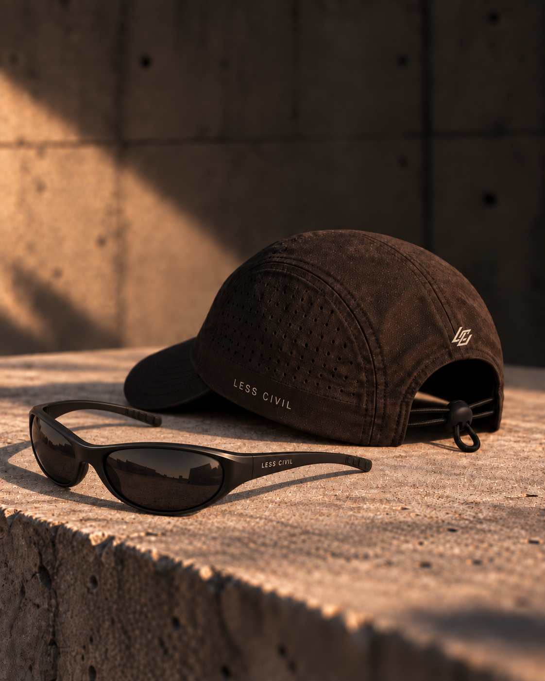 AI design study of an ink-brown cord-toggle cap with small LESS CIVIL branding, next to curved black sunglasses.